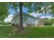 Home exterior featuring a lush, grassy backyard with mature trees and landscaping at 1 Plowlan Ct, Durham, NC 27707