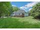 Spacious backyard with a large wooden deck, lush green grass, and surrounding trees at 1 Plowlan Ct, Durham, NC 27707