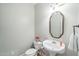 Stylish powder room with decorative mirror and white pedestal sink with floral accents at 1 Plowlan Ct, Durham, NC 27707