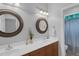 Bright bathroom featuring double sinks, decorative mirrors, and a connecting toilet and shower room at 1 Plowlan Ct, Durham, NC 27707