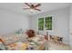 Cozy bedroom features two twin beds, ceiling fan, and natural light from the window at 1 Plowlan Ct, Durham, NC 27707