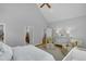 Bright bedroom with vaulted ceilings showing doorway, walk-in closet, and dresser at 1 Plowlan Ct, Durham, NC 27707