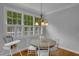Bright dining area with large windows, a round table with seating, and hardwood flooring at 1 Plowlan Ct, Durham, NC 27707