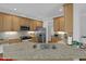 Kitchen island with granite countertop and stainless steel sink, complimented by light wood cabinets at 1 Plowlan Ct, Durham, NC 27707
