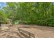 Community playground with slides, swings, picnic tables, and benches, surrounded by trees at 1 Plowlan Ct, Durham, NC 27707