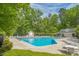 Community pool with swimming lanes, lounge chairs and tables, surrounded by trees at 1 Plowlan Ct, Durham, NC 27707