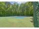 Community tennis court surrounded by a chain-link fence and lush green trees at 1 Plowlan Ct, Durham, NC 27707