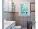 Neutral bathroom with a white toilet and sink, tiled walls, and a window at 1013 Graham St, Burlington, NC 27217