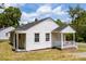 Charming single story home featuring white siding, a covered porch, and a brick foundation at 1013 Graham St, Burlington, NC 27217