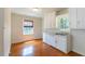 Functional kitchen space featuring wood floors, white cabinets and plenty of light; ready for your personal touches at 1013 Graham St, Burlington, NC 27217