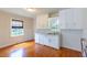 Classic kitchen area featuring wood floors, white cabinets and lots of light; great potential for custom upgrades at 1013 Graham St, Burlington, NC 27217