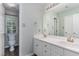 Bathroom with double sink vanity, a large mirror and a separate toilet area with window at 102 Martins Point Pl, Cary, NC 27519