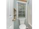Bathroom with a toilet near a window and a bathtub shower behind a curtain at 102 Martins Point Pl, Cary, NC 27519
