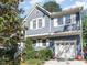 Charming two-story home with blue siding, white trim, and a two-car garage at 102 Martins Point Pl, Cary, NC 27519