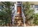 Charming entrance with wood stairs leading to a glass front door framed by lush greenery at 102 Martins Point Pl, Cary, NC 27519