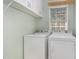 Laundry room with overhead cabinets and modern white washer and dryer at 102 Martins Point Pl, Cary, NC 27519