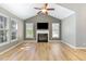 Bright living room boasts a fireplace, wood floors, vaulted ceilings, and natural light from large windows at 102 Martins Point Pl, Cary, NC 27519