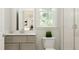 Bright bathroom with a neutral vanity, a toilet, and a window at 104 Corapeake Way, Apex, NC 27539