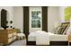 Neutral-toned bedroom with a woven bed frame, decorative pillows and dresser at 104 Corapeake Way, Apex, NC 27539