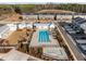 Aerial shot of a community pool and amenities nestled among modern townhouses with ample parking at 104 Vallco Ln, Durham, NC 27713