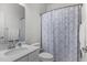 Bright bathroom featuring a single vanity, a toilet, and a blue patterned shower curtain at 104 Vallco Ln, Durham, NC 27713
