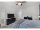 Bright bedroom featuring a ceiling fan, dark dresser with a TV, and calming blue accents at 104 Vallco Ln, Durham, NC 27713