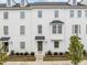 Charming townhouse featuring a light gray exterior, trimmed shrubbery, and a well-manicured lawn at 104 Vallco Ln, Durham, NC 27713