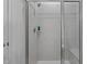 Tiled shower with glass doors, a shower seat, and tiled walls at 104 Vallco Ln, Durham, NC 27713