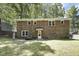 View of a brick house from the backyard, featuring mature trees at 106 Argyle Ct, Garner, NC 27529