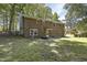View of the brick back exterior of the home with a yard, door, and trimmed green trees at 106 Argyle Ct, Garner, NC 27529