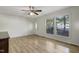Bright living room with laminate flooring, a ceiling fan, and natural light from the large windows at 106 Argyle Ct, Garner, NC 27529