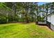 A picturesque backyard with mature trees and a partial view of the house and deck at 109 Riverbend Dr, Archer Lodge, NC 27527