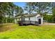 A home's exterior with a wooden deck and fenced backyard, surrounded by mature trees at 109 Riverbend Dr, Archer Lodge, NC 27527
