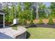 This backyard showcases landscaping, a stone patio, a lawn, a wooden fence, and a storage shed at 1102 Birchbark Rd, Durham, NC 27705