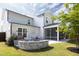 This backyard features a stone patio, a fire pit, a lawn, and a screened-in porch on a two-story home at 1102 Birchbark Rd, Durham, NC 27705