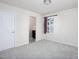 This bedroom features neutral walls and carpeting, a window with blinds, and an ensuite bathroom at 1102 Birchbark Rd, Durham, NC 27705