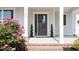 Close-up of front porch with gray door, decorative plants, and vibrant flowers at 1102 Birchbark Rd, Durham, NC 27705
