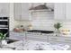 Charming kitchen with stainless steel vent hood, white cabinets, granite countertops, and modern appliances at 1102 Birchbark Rd, Durham, NC 27705