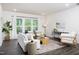 Spacious living room with hardwood floors, stylish furniture, and large windows at 1102 Birchbark Rd, Durham, NC 27705