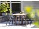 This patio features a light wood table surrounded by 4 dark metal chairs, under the shade of greenery at 1102 Birchbark Rd, Durham, NC 27705