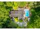 Aerial view of home with private swimming pool surrounded by mature trees and manicured landscaping at 1111 Sourwood Cir, Chapel Hill, NC 27517