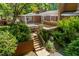 Lovely backyard featuring a wooden deck, screened porch, and access stairs surrounded by lush landscaping at 1111 Sourwood Cir, Chapel Hill, NC 27517