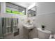 Bathroom with white tile, pedestal sink, toilet, window with lush greenery at 1111 Sourwood Cir, Chapel Hill, NC 27517