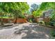 Exterior of home with brick accents, wooden stairs leading to deck and shaded gravel parking area at 1111 Sourwood Cir, Chapel Hill, NC 27517