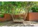 Exterior shot of brick retaining wall, wooden bench, and shade trees at 1111 Sourwood Cir, Chapel Hill, NC 27517
