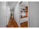 Hallway with hardwood floors and a built-in desk with white cabinets and shelving at 1111 Sourwood Cir, Chapel Hill, NC 27517