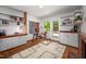Home office with a modern desk, brick fireplace, hardwood floors, and natural light at 1111 Sourwood Cir, Chapel Hill, NC 27517