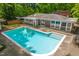 Aerial view of private backyard pool surrounded by lush greenery and a modern home at 1111 Sourwood Cir, Chapel Hill, NC 27517