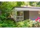 Charming sunroom with white railings, exterior lighting, and surrounded by lush greenery at 1111 Sourwood Cir, Chapel Hill, NC 27517