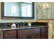 Elegant bathroom vanity with dark wood cabinetry, granite countertop, undermount sink, and decorative mirror at 113 Ruskin Dr, Chapel Hill, NC 27516